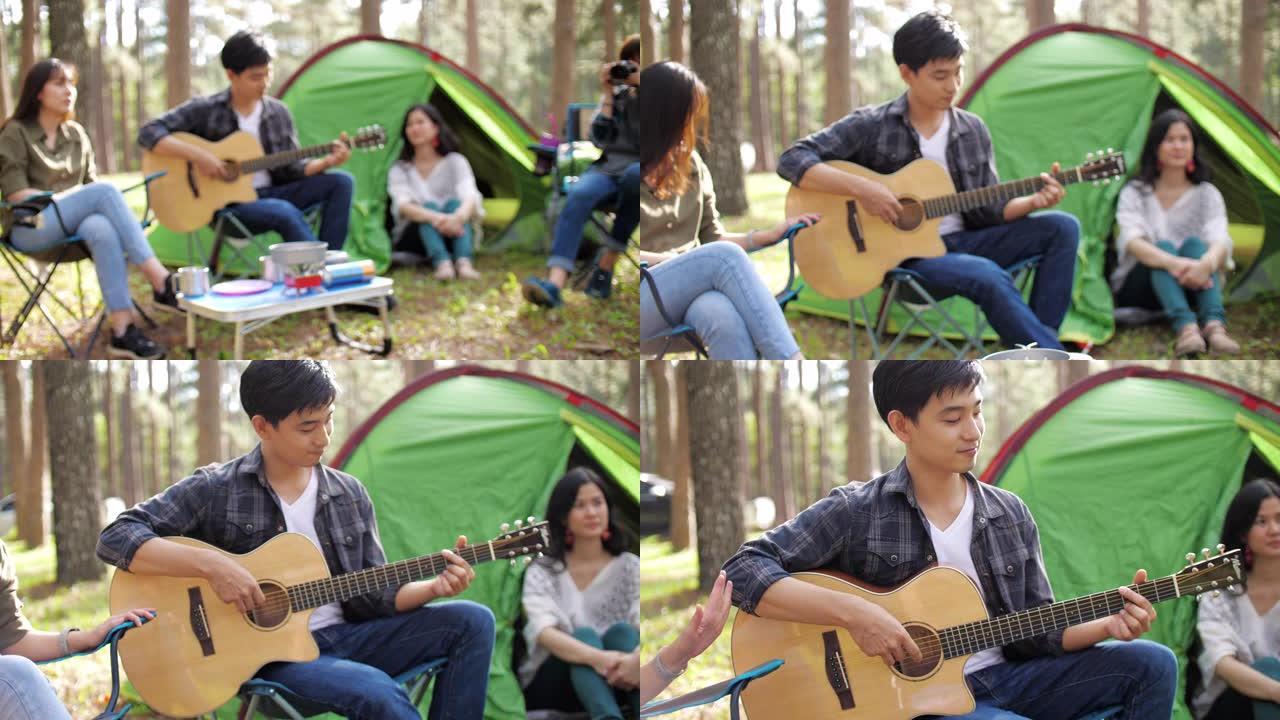一群朋友在松树露营地露营和弹吉他快乐和享受