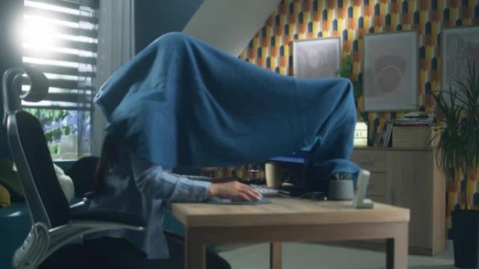 用毯子盖着电脑的女人