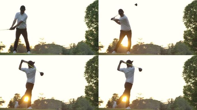 亚洲男子高尔夫球手挥杆高尔夫球杆，以慢动作击打日落背景的高尔夫球。