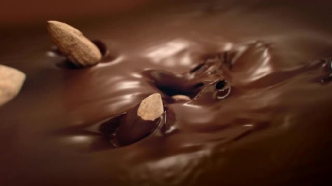 杏仁坚果在4k超慢动作中落入液体巧克力中