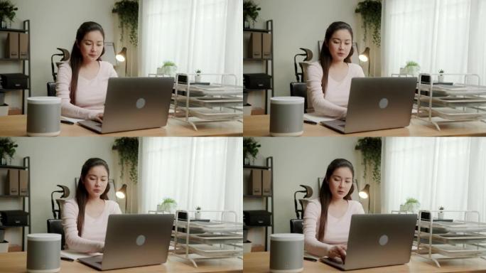 智能扬声器数字助理技术。女人在笔记本电脑上工作时向智能扬声器设备提问。
