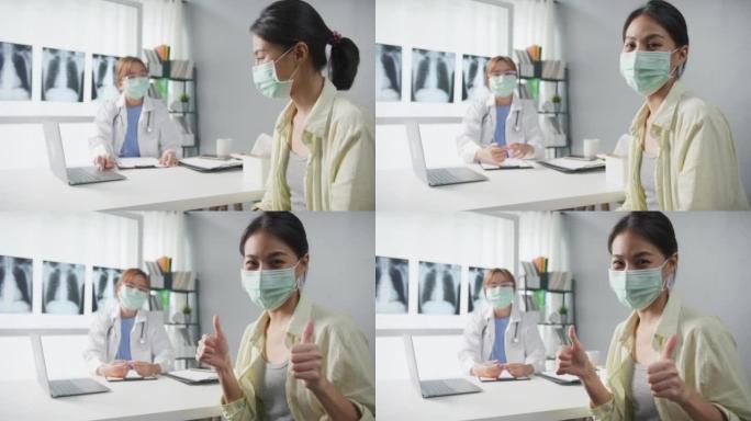自信的亚洲女医生戴着防护口罩，年轻的病人女孩看着相机，微笑着在诊所或医院的办公桌上进行医疗咨询。