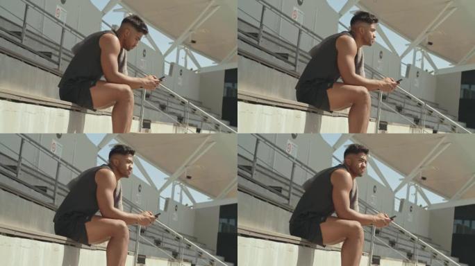 一名男运动员在体育场使用手机的4k录像