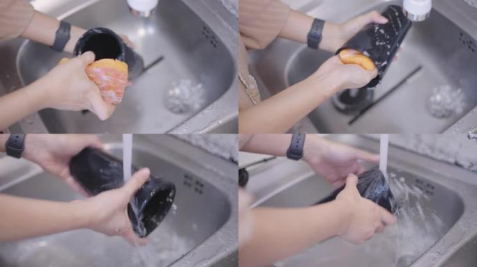 女人手清洁可重复使用的吸管和黑色瓶子