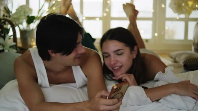 情侣在床上玩智能手机