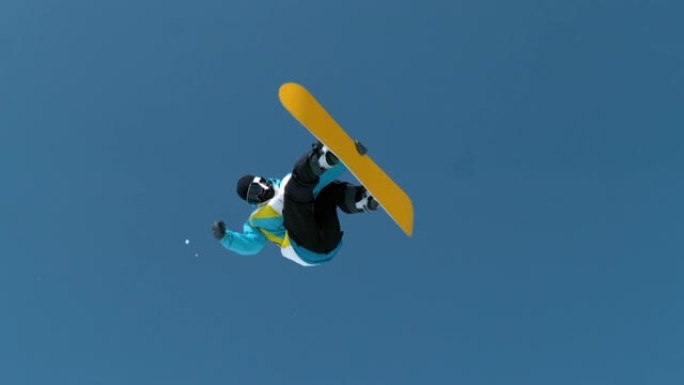 慢动作时间扭曲: 滑雪者跳跃并执行旋转抓斗技巧。