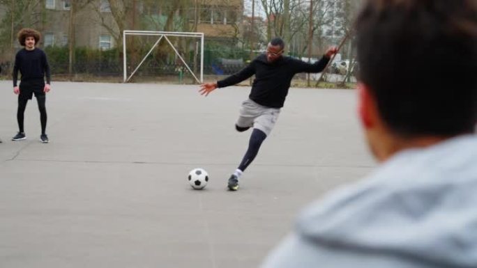 足球运动员在街头球场上踢点球
