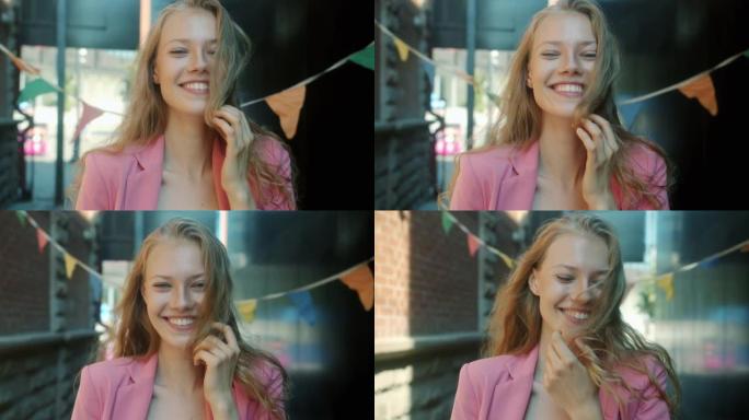快乐的女学生在城市外面笑着看着相机的慢动作肖像
