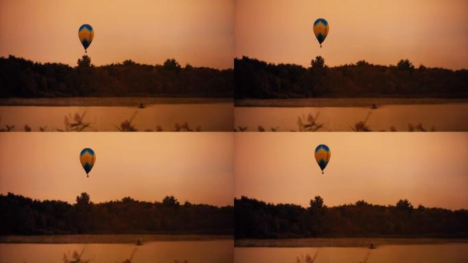 热气球在树木和湖泊上的宁静天空中上升