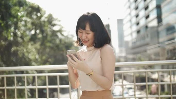 亚洲女子跳舞用智能手机欣赏音乐