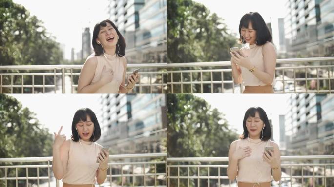 亚洲女子跳舞用智能手机欣赏音乐