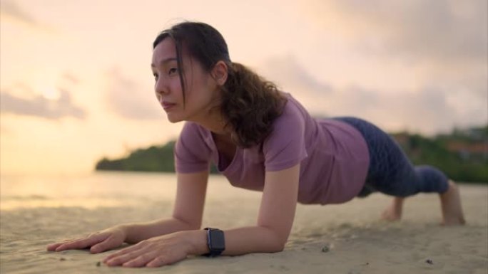 亚洲运动女子在沙滩上练习瑜伽