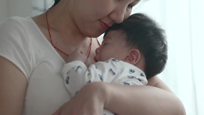婴儿手和妈妈的软焦点。将熟睡的婴儿交在母亲的手中，近距离接触，新家庭和婴儿保护免受妈妈的概念。