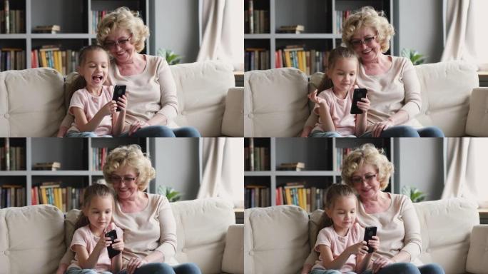 小孙女在家和奶奶玩手机游戏。