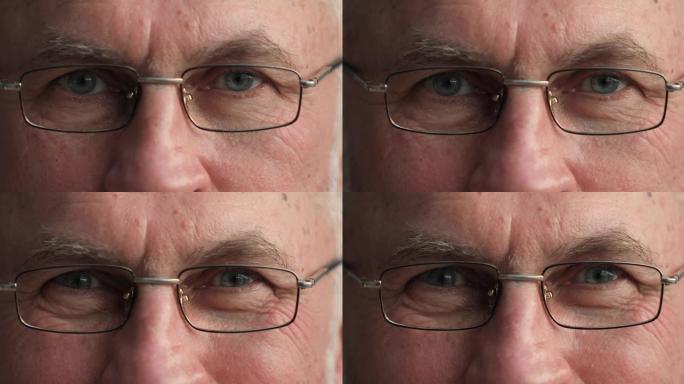 老人的灰色眼睛透过眼镜看着相机