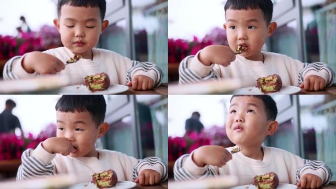 小男孩在餐厅吃蛋糕