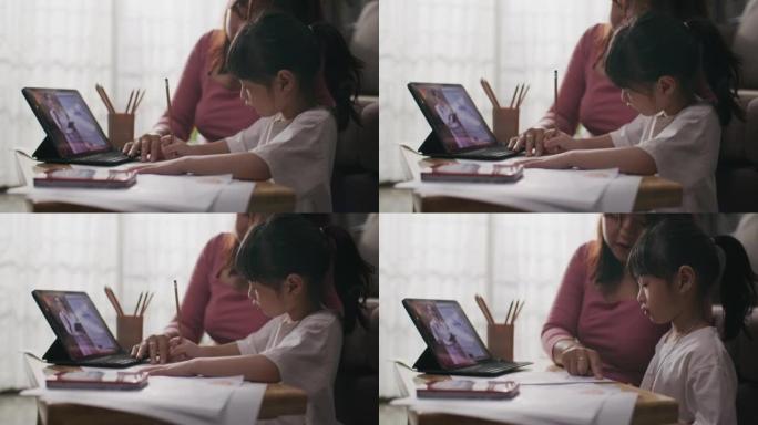 通过数字远程互联网会议从学校老师那里获得的年轻亚洲母女在线课程