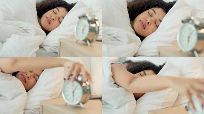 闹钟，早晨和疲倦的女人在睡觉时对噪音感到沮丧，对时间感到悲伤，并在家里的床上休息。愤怒，不快乐和非洲