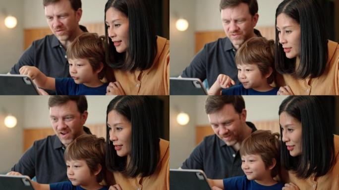幸福的家庭坐在一起在数字平板电脑上玩游戏