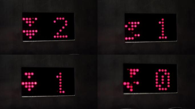 电梯显示器，数字为闪电红色，下降。特写。