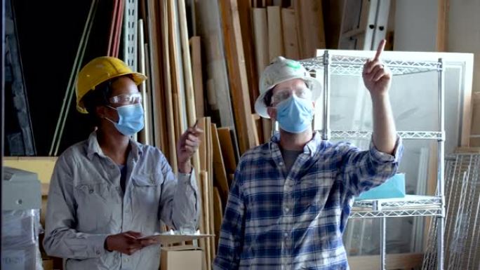 男人和女人在仓库工作，戴着口罩