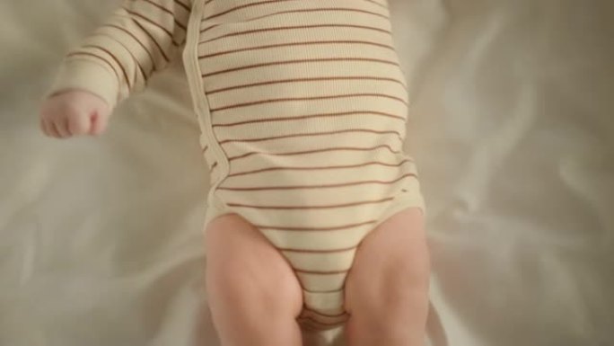 特写镜头，一个可爱的新生婴儿躺在婴儿床的背上。小小的高加索人新生儿蹒跚学步是水平的。童年、新生活和为