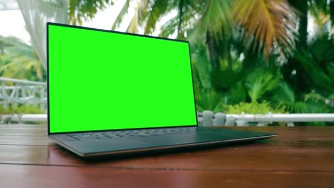 户外木桌上绿屏笔记本电脑