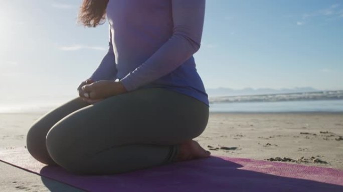 混血女子在沙滩上冥想瑜伽垫