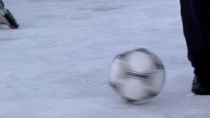 孩子们在雪地里踢足球比赛。低角度视图。