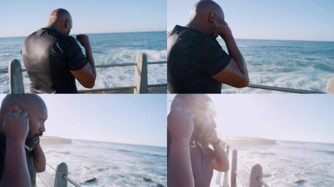 健身，运动和海滩长廊上的黑人男子用耳机听音乐，以激发动力和精力进行有氧运动。海上健美男，户外跑步播客