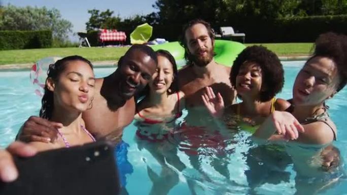 多样化的朋友在游泳池里自拍照