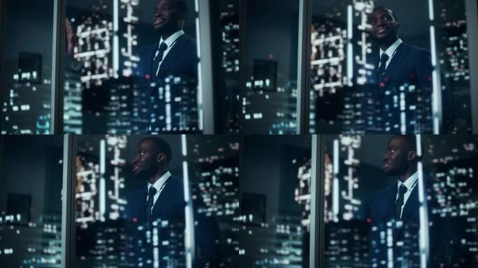 穿着定制西装的成功黑人商人站在他的办公室里，看着夜城的窗外。成功投资经理工作后期规划电子商务服务购买