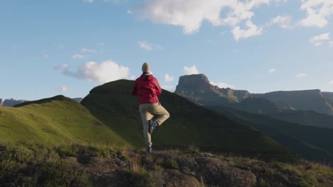 一个年轻健康的男人在山上徒步旅行的壮观景色。自由。成就。禅宗般的