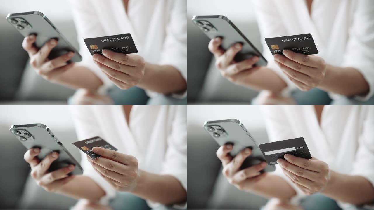 女人的特写手正在使用带有信用卡的智能手机在线购物