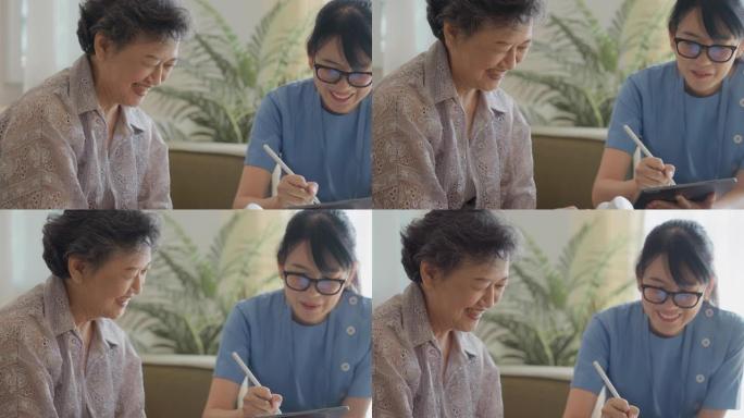 亚洲护士在家访期间使用数字平板电脑与患者交谈。