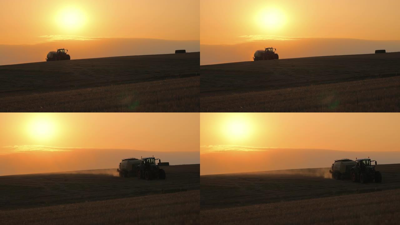 日落时在田野上行驶的拖拉机的SLO MO剪影