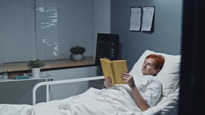 妇女在医院病床上读书