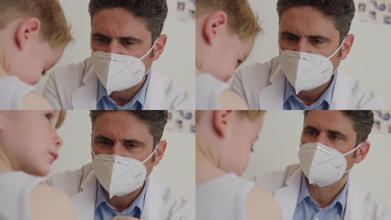 儿科医生戴着口罩给男孩注射流感疫苗