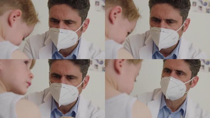 儿科医生戴着口罩给男孩注射流感疫苗
