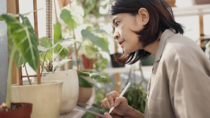 花店ckecking植物并在花园中心使用数字平板电脑