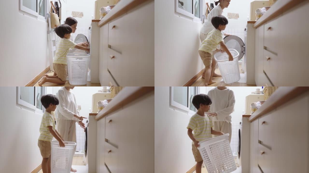 男孩和年轻的母亲把衣服放进洗衣机