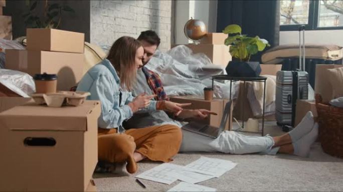 申请信贷，网上贷款。快乐兴奋的夫妇在纸板箱里用笔记本电脑在线购物。