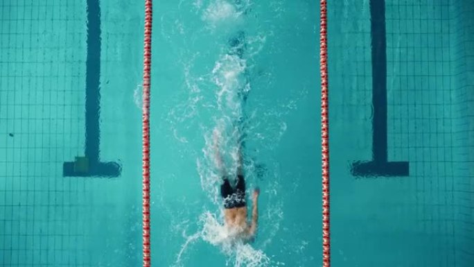 空中俯视图男游泳者在游泳池里，做圈，转弯。专业运动员训练比赛，赢得世界冠军自由泳。电影宽慢动作固定镜