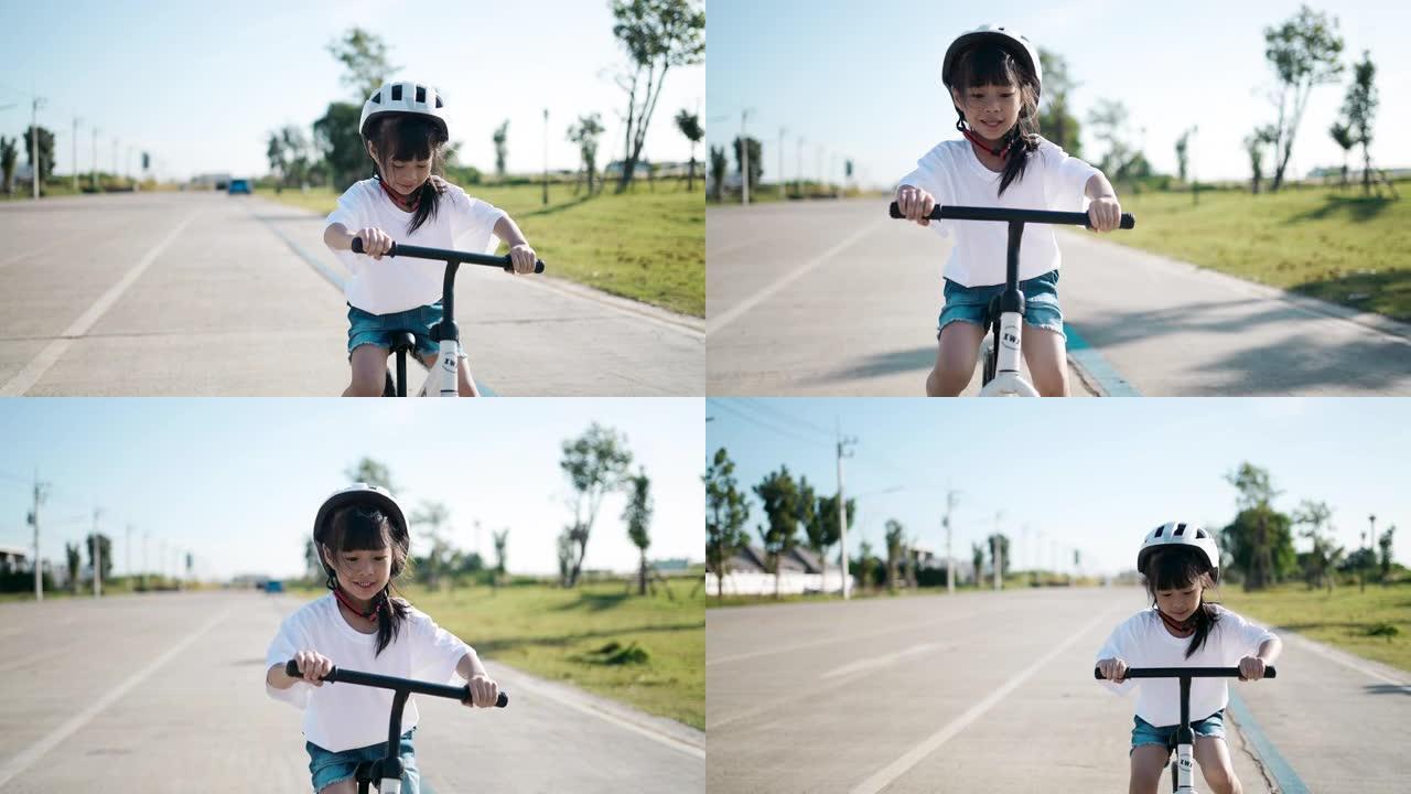 骑平衡自行车的女孩，带着运动头盔骑自行车玩得开心