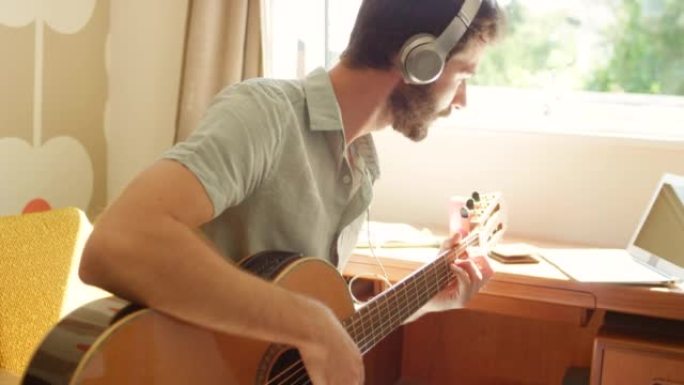 一个年轻人录制自己弹吉他的4k视频片段