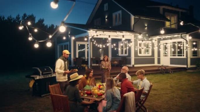 一群多民族的人在户外用餐时玩得开心，互相交流。在一个温暖的夏日傍晚，家人和朋友聚集在他们的家外。