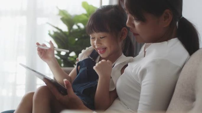 亚洲母女在家一起使用数字平板电脑，在线课程