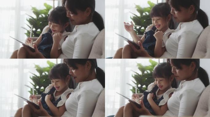 亚洲母女在家一起使用数字平板电脑，在线课程