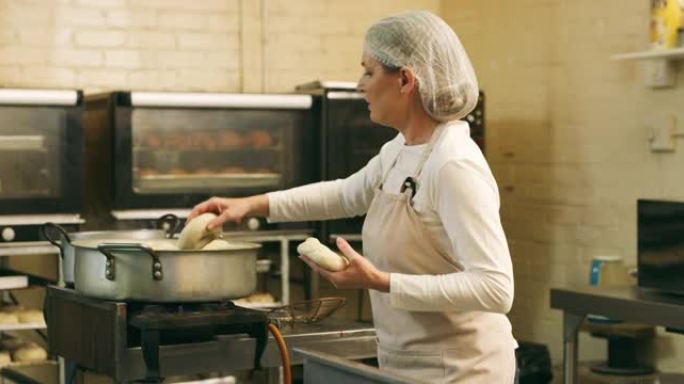 一个成熟的女性面包师在面包店准备百吉饼的4k录像