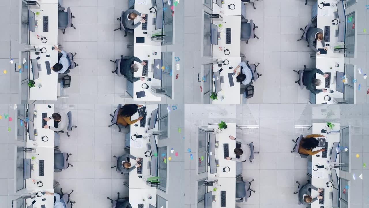 一个繁忙的公司办公室的自上而下的镜头，其中有两排在台式计算机上工作的商人和女商人。同事之间互联技术社